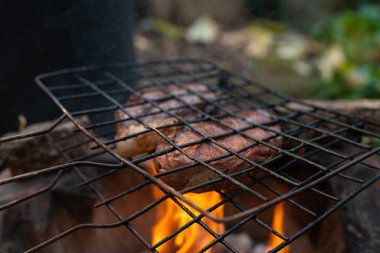 Açık havada ateşte sığır eti ızgarası, orta pişmiş çiğ yemek.