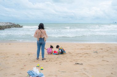 Mutlu Asyalı çocuklar erkek ve kız egzotik deniz plajı yaz tatili konseptinde oyuncak oynuyorlar.
