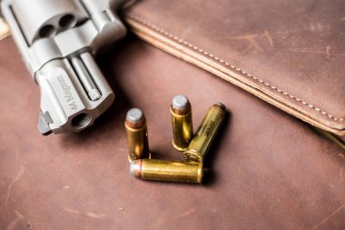 44 magnum revolver, deri arka planda nefsi müdafaa mermisi olan klasik silahı gizler.