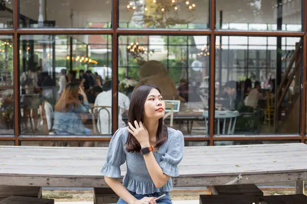 Şehirdeki kafede oturan güzel Asyalı kadın hafta sonu iş kadınını rahatlatıyor.