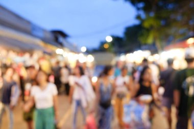 Soyut bulanık insanlar açık hava pazarında güneşli bir günde yürüyorlar.