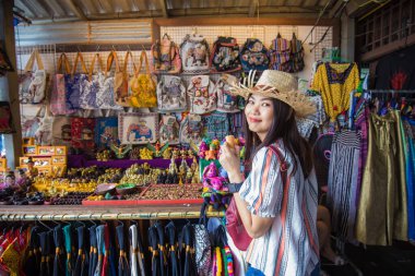 Bangkok 'ta kadın seyahati hediyelik eşya dükkanında hafta sonu Tayland pazarının keyfini çıkarıyor