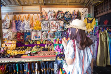 Woman travel in Bangkok city enjoy shopping in souvenir shop weekend market Thailand clipart