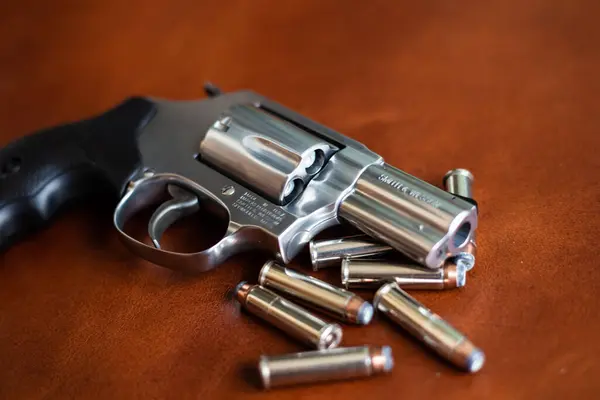 stock image 357 magnum concealed revolver gun personal defence on brown leather background