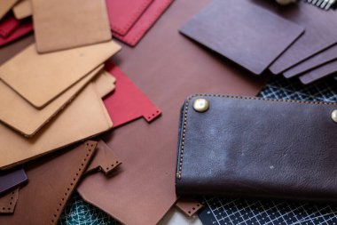 Gerçek deri cüzdanın arka planında el yapımı bir cüzdan var.