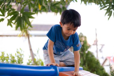 Çocuk arkadaş grubu tırmanma ve oyun parkında koşma keyfini çıkarıyor. Çocuklar dışarıda egzersiz yapıyor.