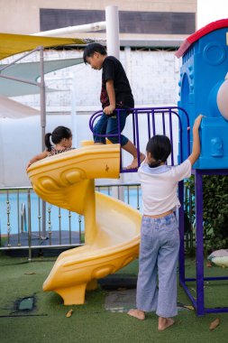 Çocuk arkadaş grubu tırmanma ve oyun parkında koşma keyfini çıkarıyor. Çocuklar dışarıda egzersiz yapıyor.