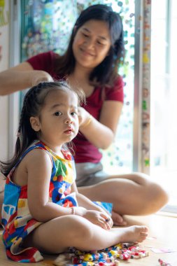 Çok güzel Asyalı bir anne ve çok güzel bir kızı var.