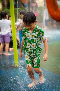 Mutlu Asyalı anaokulu çocuğu Aqua Park 'ta yaz tatili aktivitelerinin tadını çıkarıyor.