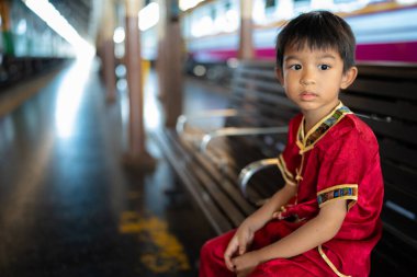 Küçük Asyalı çocuk geleneksel takım elbise giyer. Eski tren istasyonu Bangkok Tayland 'a gider.