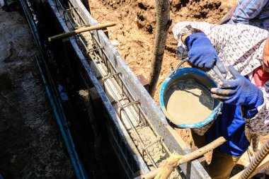 İnşaat işçileri beton duvara beton döküyor. Yeni ev inşaat endüstrisi.