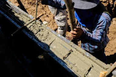 İnşaat işçileri beton duvara beton döküyor. Yeni ev inşaat endüstrisi.
