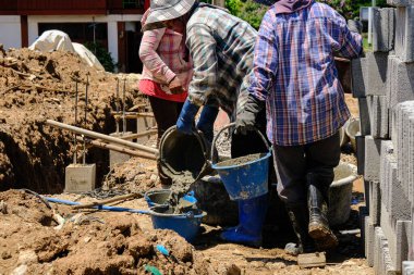 İnşaat işçileri beton duvara beton döküyor. Yeni ev inşaat endüstrisi.
