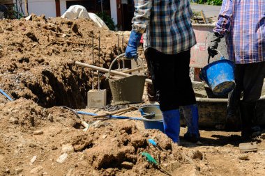 İnşaat işçileri beton duvara beton döküyor. Yeni ev inşaat endüstrisi.