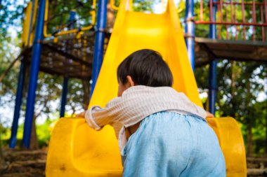 Anaokulundaki çocuk oyun parkında sürgülü oyun oynuyor.