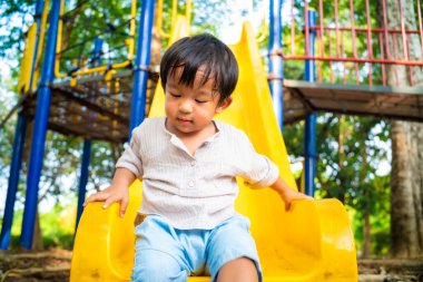 Anaokulundaki çocuk oyun parkında sürgülü oyun oynuyor.