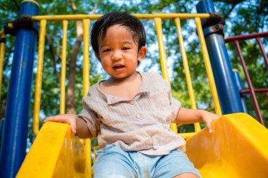 Anaokulundaki çocuk oyun parkında sürgülü oyun oynuyor.