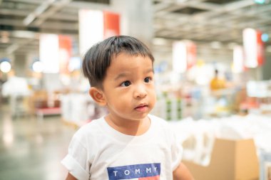 Küçük çocuk hafta sonu süpermarkette alışveriş yapmaktan zevk alıyor.