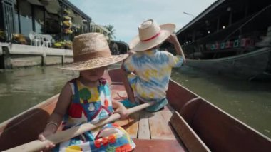 Bangkok, Tayland yakınlarındaki Ratchaburi 'deki Damnoen Saduak yüzer pazarındaki çocuklar.