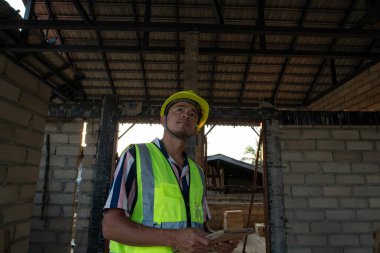 İnşaat sahasında tablet bilgisayarla çalışan mühendis. Yeni bina içinde.