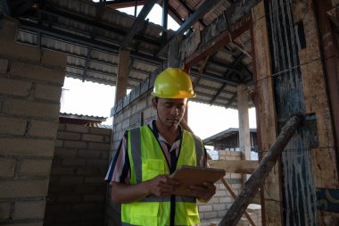 İnşaat sahasında tablet bilgisayarla çalışan mühendis. Yeni bina içinde.