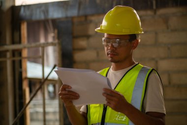 Ustabaşı müfettişi planlama mühendisiyle birlikte modern bina binasında çalışıyor.