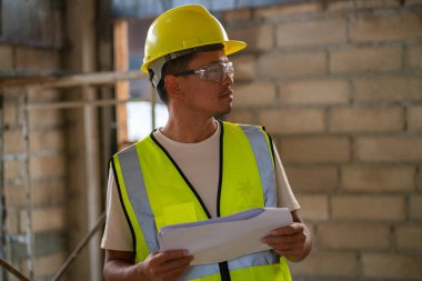 Ustabaşı müfettişi planlama mühendisiyle birlikte modern bina binasında çalışıyor.