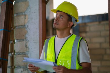 Ustabaşı müfettişi planlama mühendisiyle birlikte modern bina binasında çalışıyor.