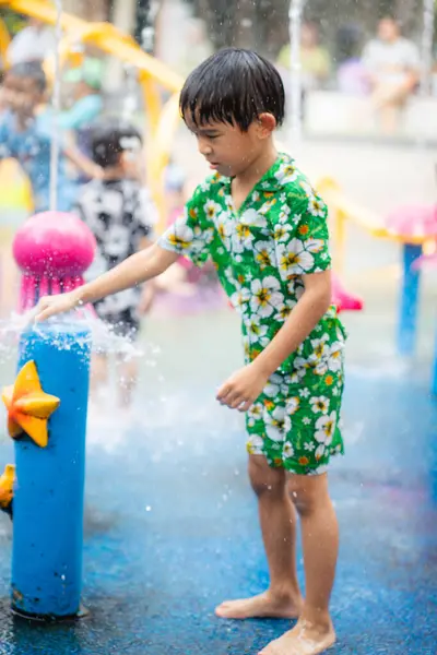 Mutlu Asyalı anaokulu çocuğu Aqua Park 'ta yaz tatili aktivitelerinin tadını çıkarıyor.