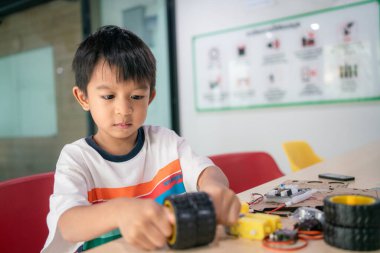 Bilgisayar Kodlama Dersinde Arduino Robot Ödevi Yapan Asyalı Mutlu Öğrencinin Portresi