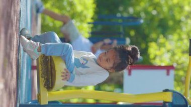 Asyalı kız oyun bahçesinde oynuyor, yaz zamanı.. 