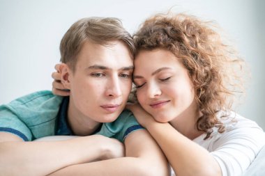 Beyaz yatakta uyuyan mutlu beyaz bir çift. Aşk romantizmi. Sevgililer Günü kavramı.