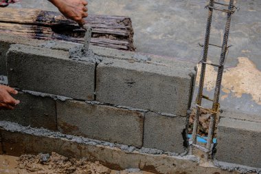 Mekanik adam tuğla duvar inşaatında çalışıyor. Yeni ev inşaatı endüstrisi.