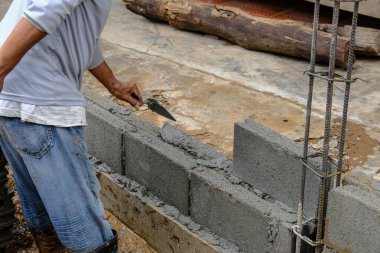 Mekanik adam tuğla duvar inşaatında çalışıyor. Yeni ev inşaatı endüstrisi.