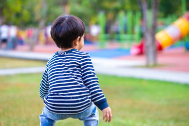 Sabahleyin yeşil çimlerde koşan sevimli küçük çocuk parkın güneş doğuşu egzersizi