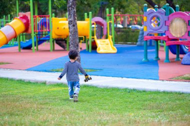 Sabahleyin yeşil çimlerde koşan sevimli küçük çocuk parkın güneş doğuşu egzersizi