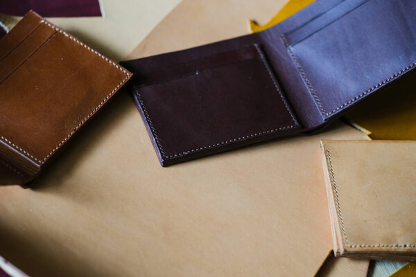 Подлинный двукратный бумажник кожа работает с инструментом мастерство на кожаном фоне ручной работы бумажник