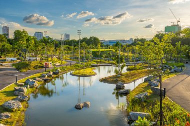 Yeşil şehir parkında yürüyüş yolu Gün batımı gökyüzü doğa manzarasını gölgeliyor