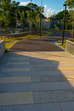 Yeşil şehir parkında yürüyüş yolu Gün batımı gökyüzü doğa manzarasını gölgeliyor