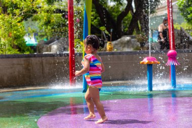 Su parkında oynayan sevimli küçük kız, yaz tatili konsepti.