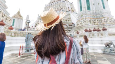 Wat Arun 'u ya da Temple of Dawn' ı ziyaret ederken gülümseyen Asyalı bir turist kız.