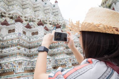 Wat Arun 'u ya da Temple of Dawn' ı ziyaret ederken gülümseyen Asyalı bir turist kız.