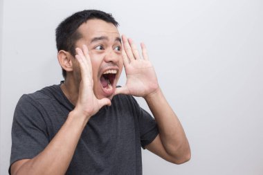 Genç Asyalı 'nın portresi beyaz arka planda bağırıyor.