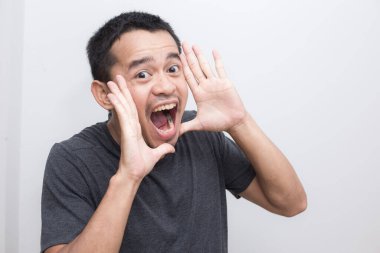 Genç Asyalı 'nın portresi beyaz arka planda bağırıyor.