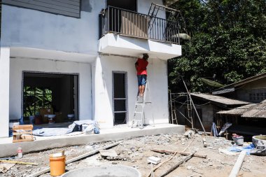 Tamirci, iki katlı, modern bir binada çalışıyor.