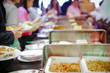 Bir grup iş adamının elleri açık büfeden kendi yemeklerini alıp, kapatıyorlar.