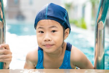 Asyalı anne, güzel kızıyla havuzda yüzüyor. Mutlu aile aktiviteleri.