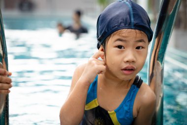 Asyalı anne, güzel kızıyla havuzda yüzüyor. Mutlu aile aktiviteleri.
