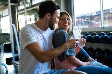 Çekici genç çift spor salonunda çalışıp biberonla su içtikten sonra bir araya geliyor. 