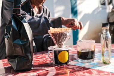 İnsanlar sabahları evdeki açık hava masasında filtrelenmiş kahve damlalarıyla konuşuyorlar.